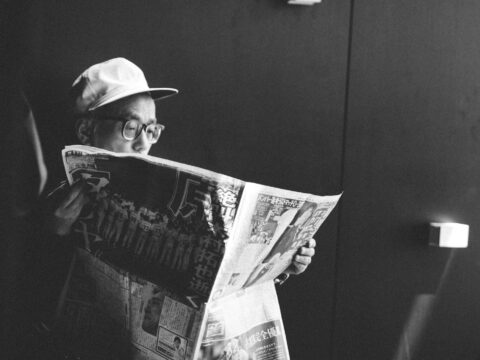 man in black shirt reading newspaper