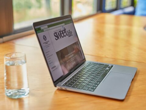 a laptop computer sitting on top of a wooden table