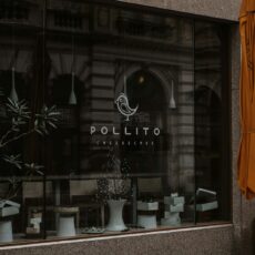 a store front with a yellow umbrella outside of it